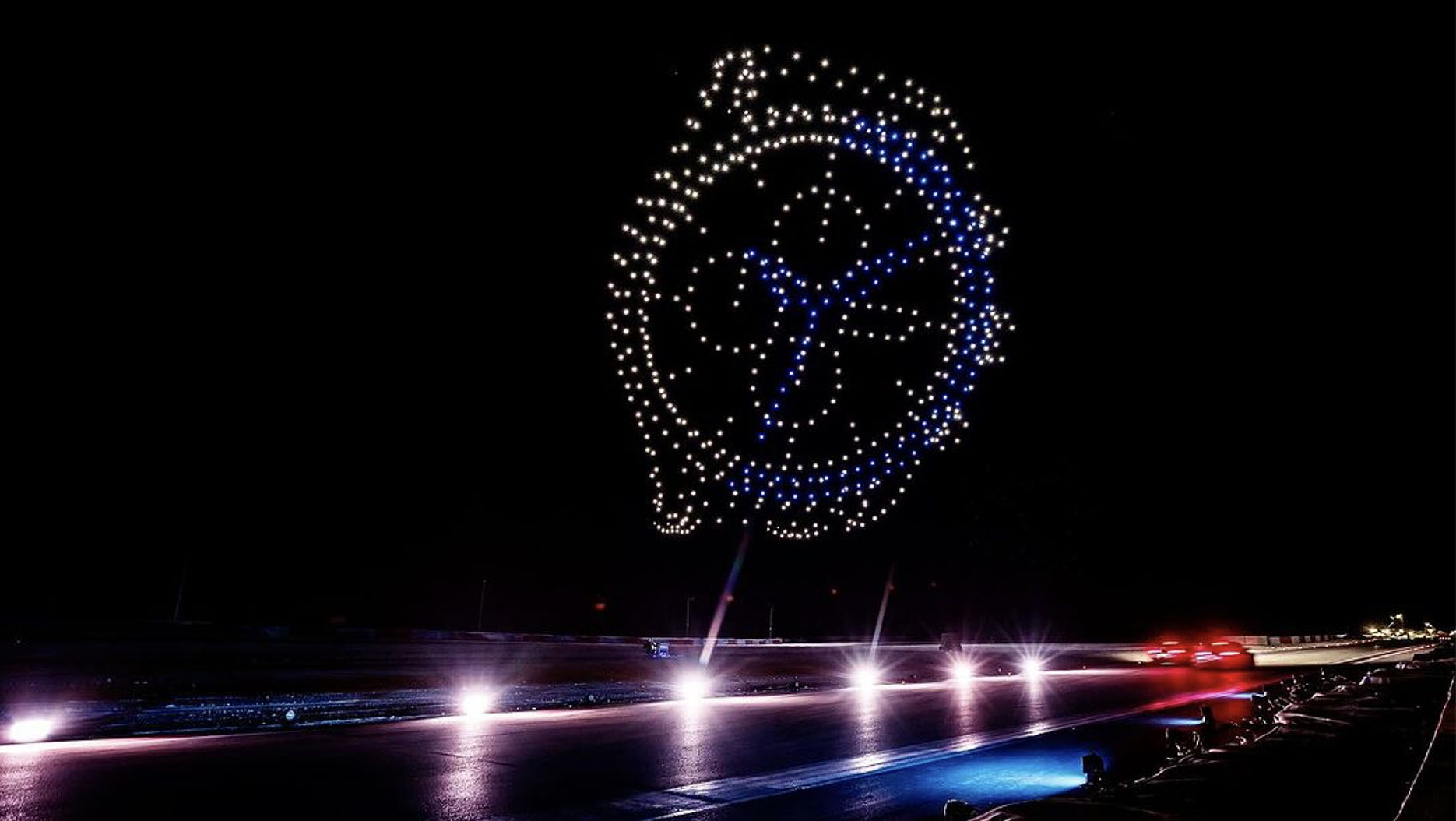 A brightly-lit watch face in the sky composed by drones during a light show.